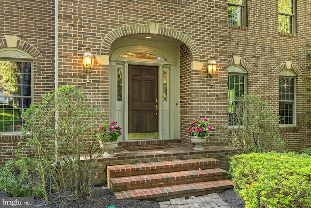 view of exterior entry featuring brick siding