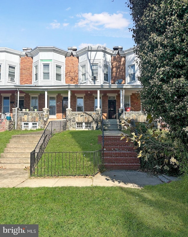 multi unit property with a fenced front yard, a chimney, stairway, covered porch, and a front yard