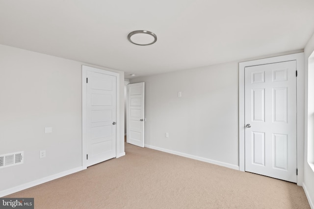 empty room with carpet floors, visible vents, and baseboards