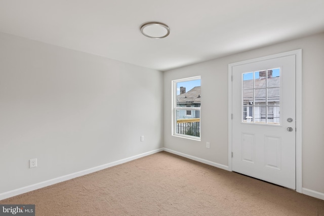 doorway with baseboards and carpet flooring