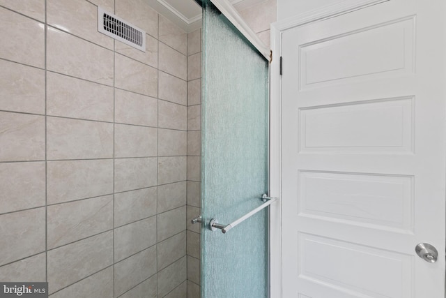 bathroom with a shower stall and visible vents