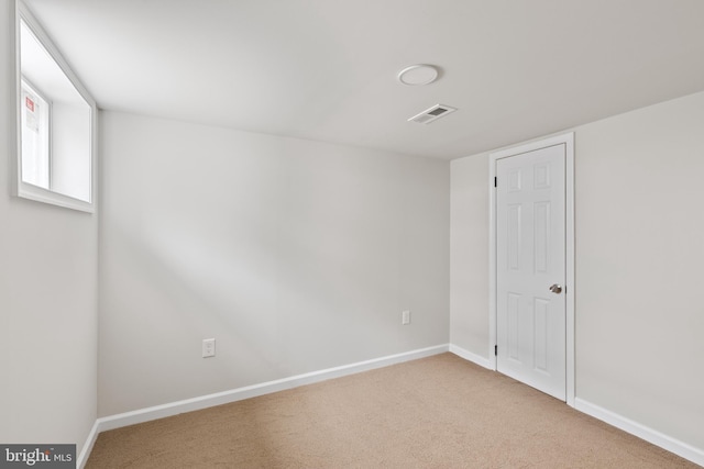 carpeted empty room featuring visible vents and baseboards