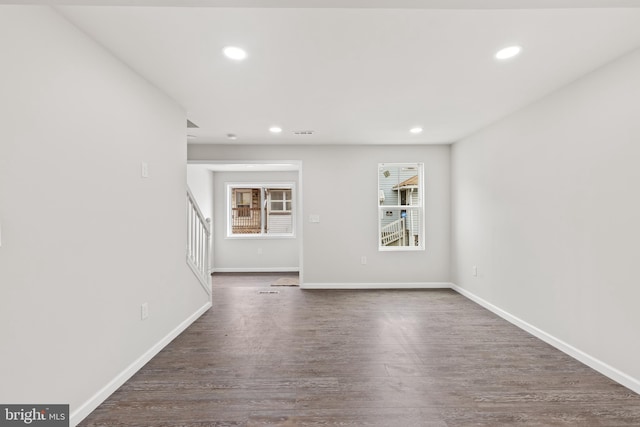 spare room with stairs, baseboards, dark wood-style flooring, and recessed lighting