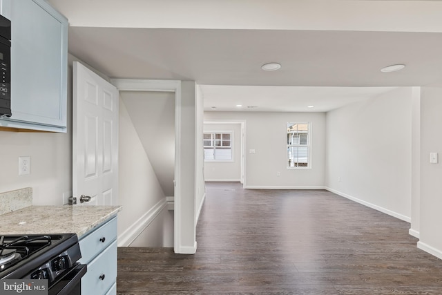 kitchen featuring baseboards, dark wood finished floors, light stone counters, and recessed lighting