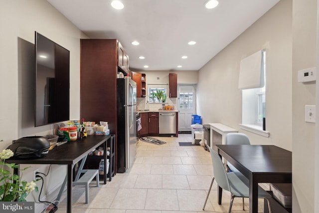 kitchen with light tile patterned floors, recessed lighting, stainless steel appliances, light countertops, and backsplash