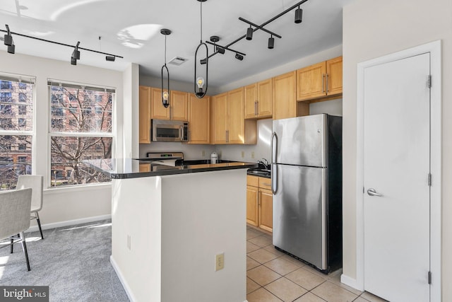 kitchen featuring a wealth of natural light, stainless steel appliances, dark countertops, and light brown cabinets