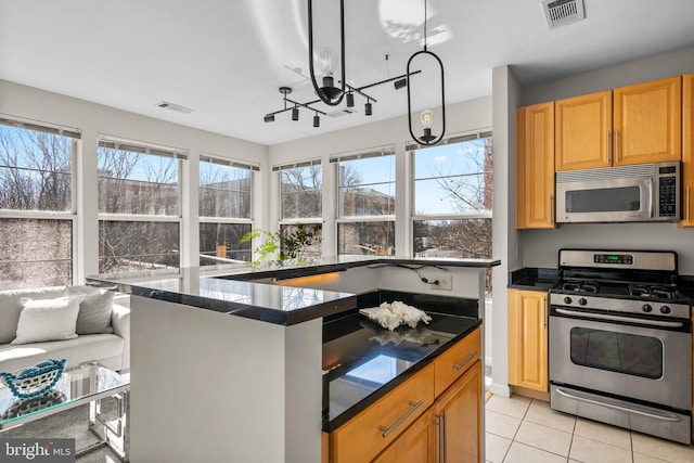 kitchen with light tile patterned floors, stainless steel appliances, a kitchen island, and visible vents