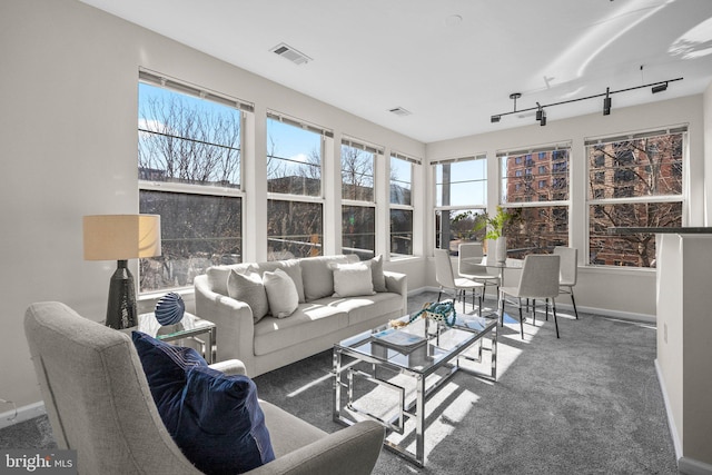 sunroom / solarium with visible vents, a healthy amount of sunlight, and rail lighting