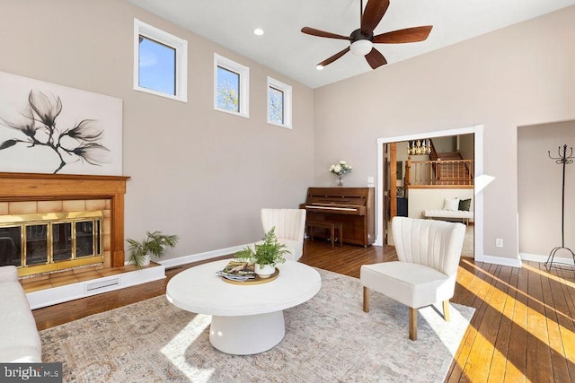 sitting room with a tile fireplace, recessed lighting, a ceiling fan, baseboards, and hardwood / wood-style floors