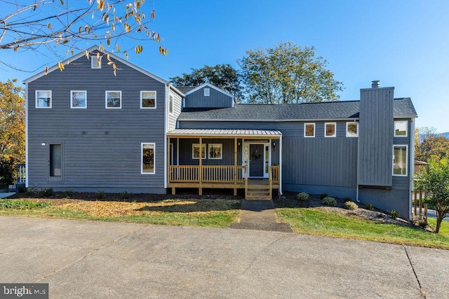 tri-level home featuring a porch and a chimney