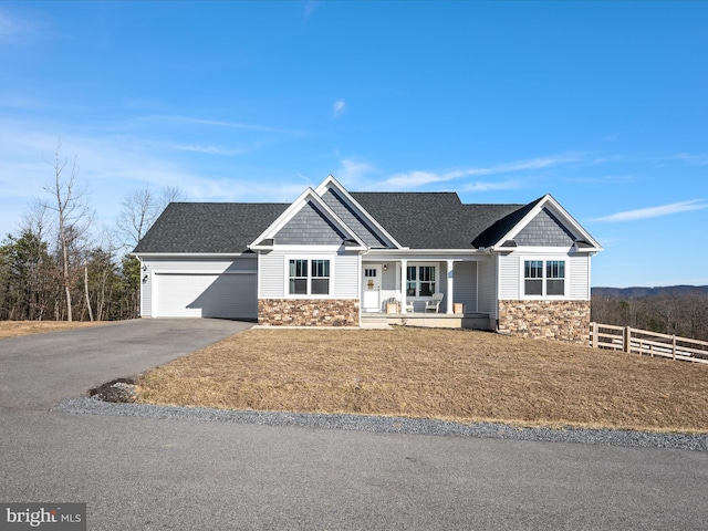 craftsman-style house featuring driveway, stone siding, an attached garage, fence, and a porch