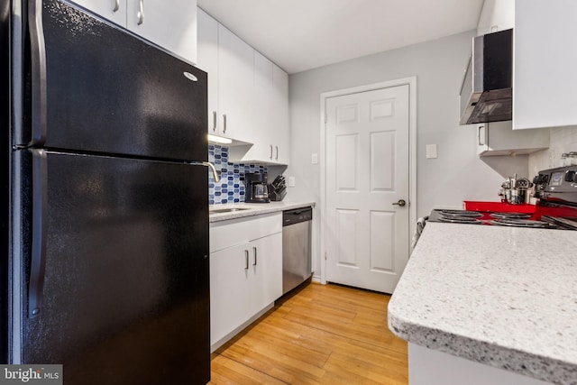 kitchen featuring stainless steel appliances, tasteful backsplash, light countertops, light wood-style flooring, and white cabinets