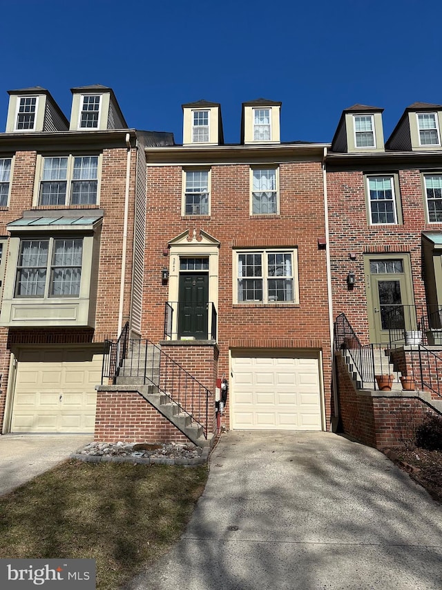 townhome / multi-family property featuring an attached garage, concrete driveway, and brick siding