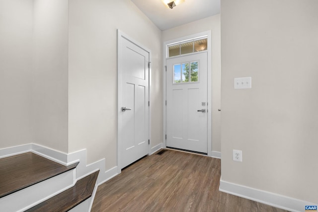 foyer featuring baseboards and wood finished floors