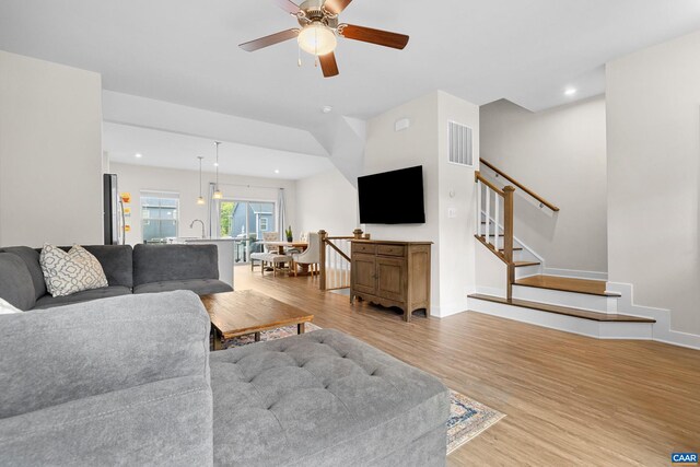 living room featuring light wood-style floors, stairs, visible vents, and recessed lighting