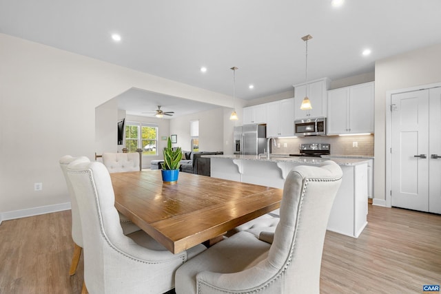 dining space featuring light wood-type flooring, baseboards, and recessed lighting