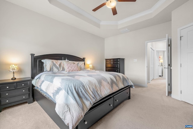 bedroom with visible vents, baseboards, a raised ceiling, a ceiling fan, and light colored carpet