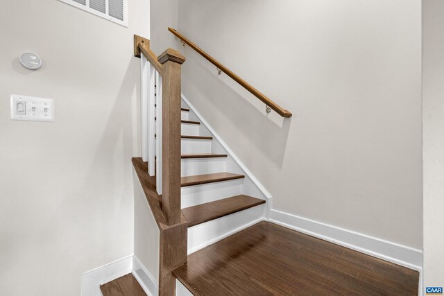 stairway with baseboards and wood finished floors