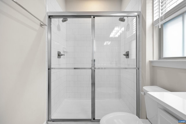 bathroom featuring a stall shower and toilet