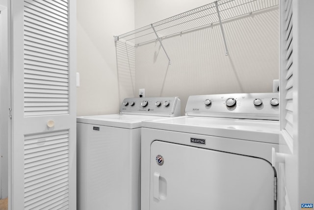 clothes washing area featuring laundry area and washer and clothes dryer