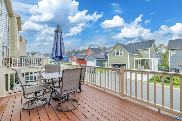 deck featuring outdoor dining area and a residential view