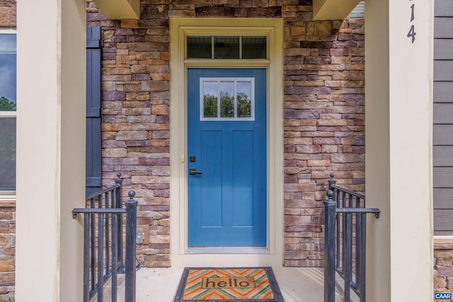 doorway to property featuring stone siding and brick siding