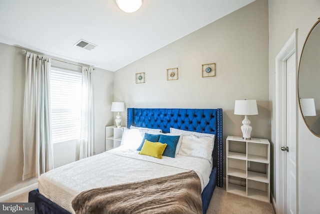 bedroom with lofted ceiling, visible vents, and carpet flooring