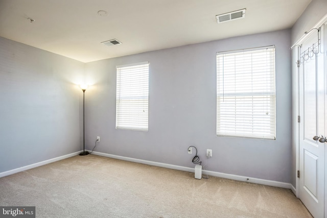 washroom featuring carpet floors, plenty of natural light, and visible vents