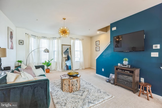 living room featuring carpet, a notable chandelier, and baseboards