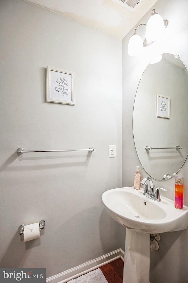 bathroom with baseboards, a sink, and wood finished floors