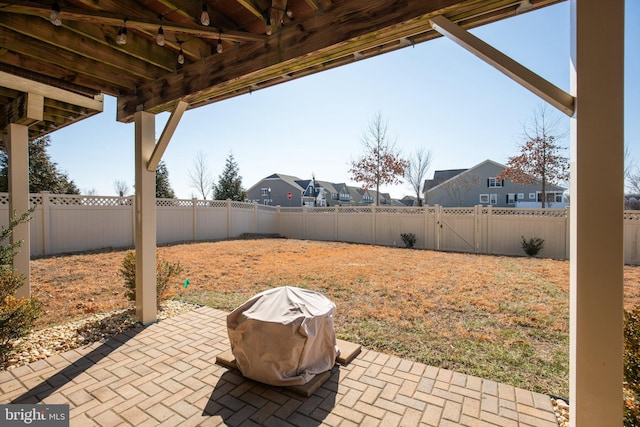 view of patio / terrace with a residential view, a fenced backyard, and a grill