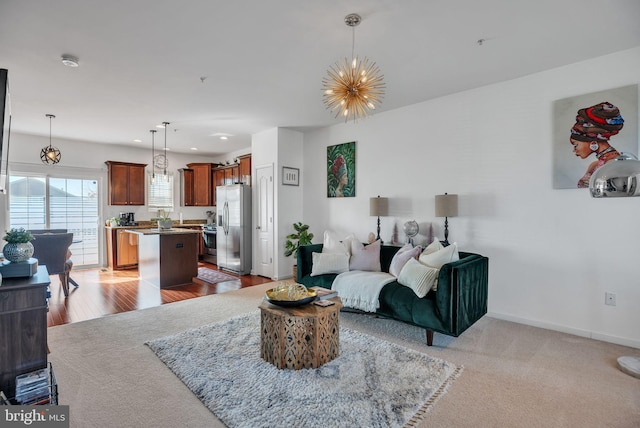 living room with a chandelier, recessed lighting, light colored carpet, and baseboards