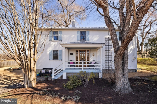 view of front of home featuring stucco siding, a chimney, a porch, fence, and stairs