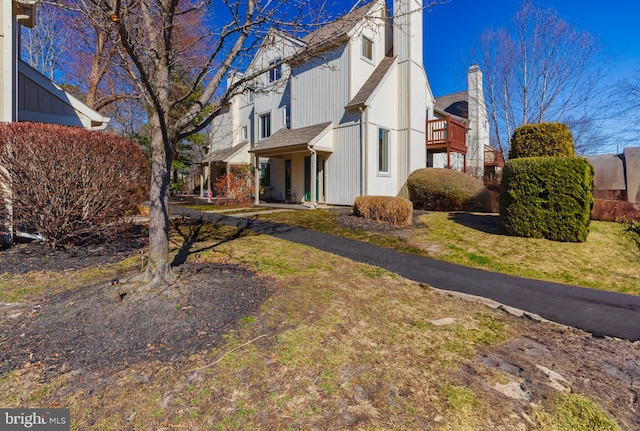 view of property exterior featuring a balcony and a chimney