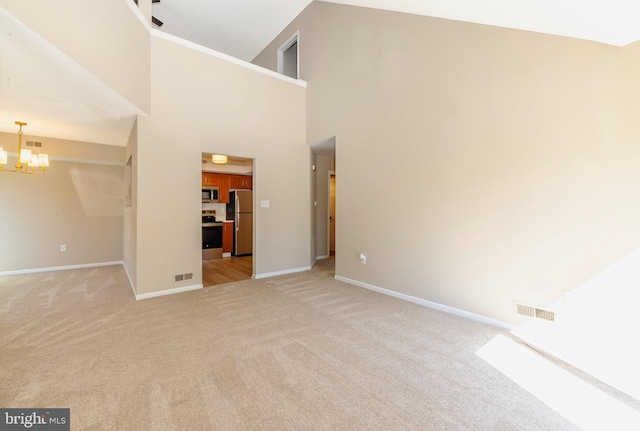 unfurnished living room with a chandelier, baseboards, visible vents, and light colored carpet