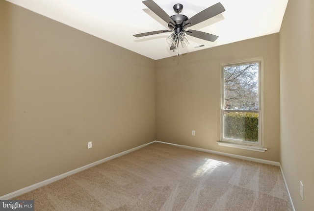 carpeted empty room featuring visible vents, baseboards, and a ceiling fan