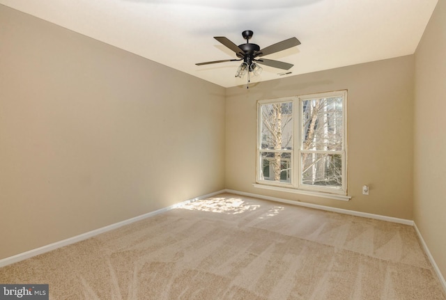 spare room with a ceiling fan, carpet, visible vents, and baseboards