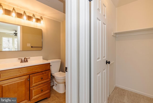 bathroom featuring baseboards, ceiling fan, vanity, and toilet