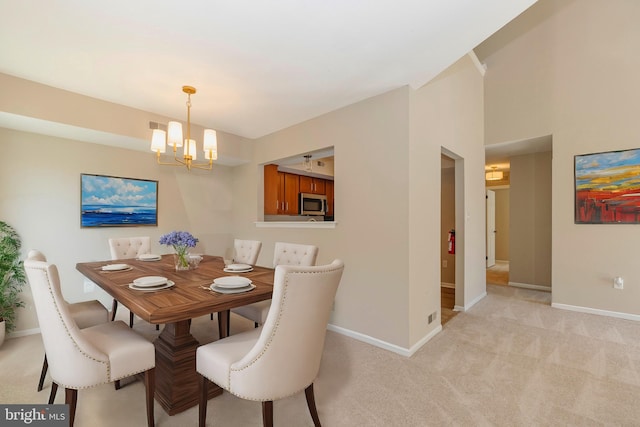 dining area with light carpet, an inviting chandelier, and baseboards