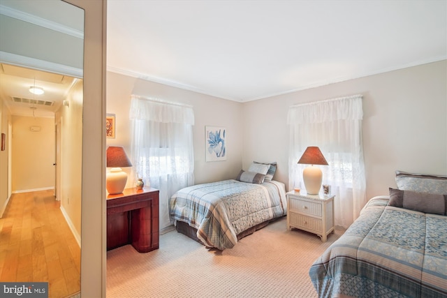 bedroom featuring visible vents, multiple windows, attic access, and crown molding