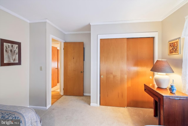 carpeted bedroom with ornamental molding, a closet, and baseboards