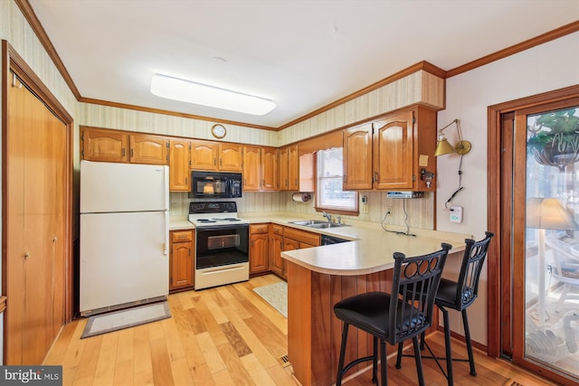 kitchen featuring ornamental molding, freestanding refrigerator, a sink, range with electric cooktop, and black microwave