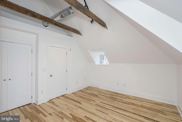 additional living space with lofted ceiling with beams, light wood finished floors, and baseboards