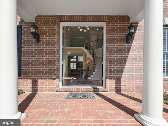 view of exterior entry featuring brick siding