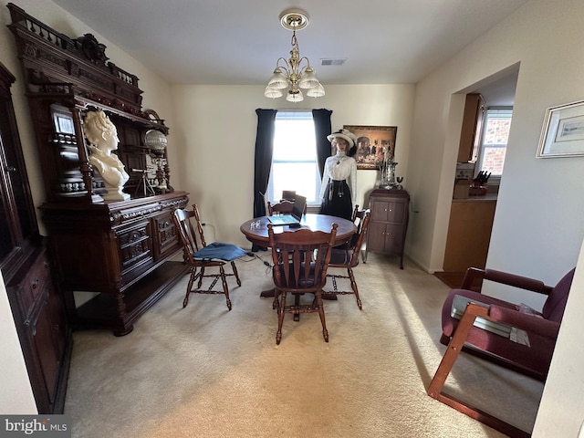 carpeted dining area with a chandelier and visible vents