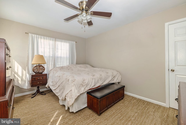 bedroom featuring light carpet, a ceiling fan, and baseboards