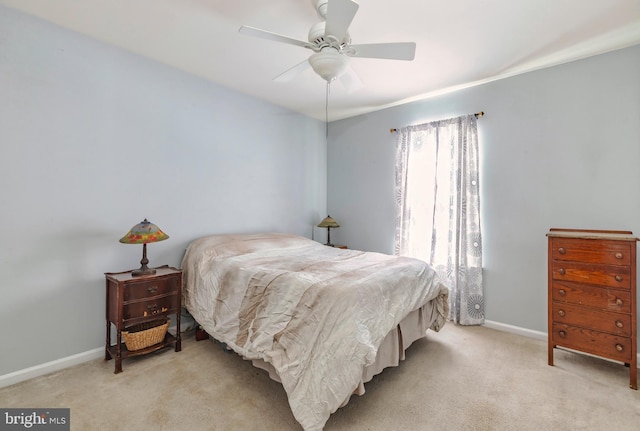 bedroom featuring baseboards, a ceiling fan, and light colored carpet