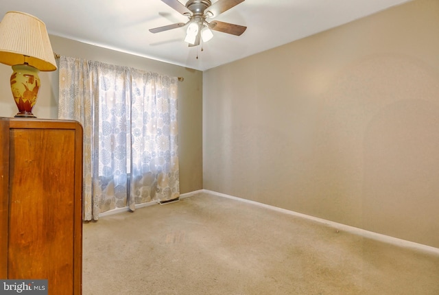 spare room featuring carpet floors, ceiling fan, and baseboards