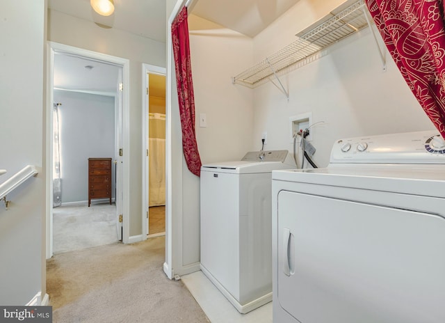 laundry room with laundry area, light carpet, baseboards, and washing machine and clothes dryer