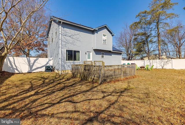 rear view of house featuring a fenced backyard and a yard